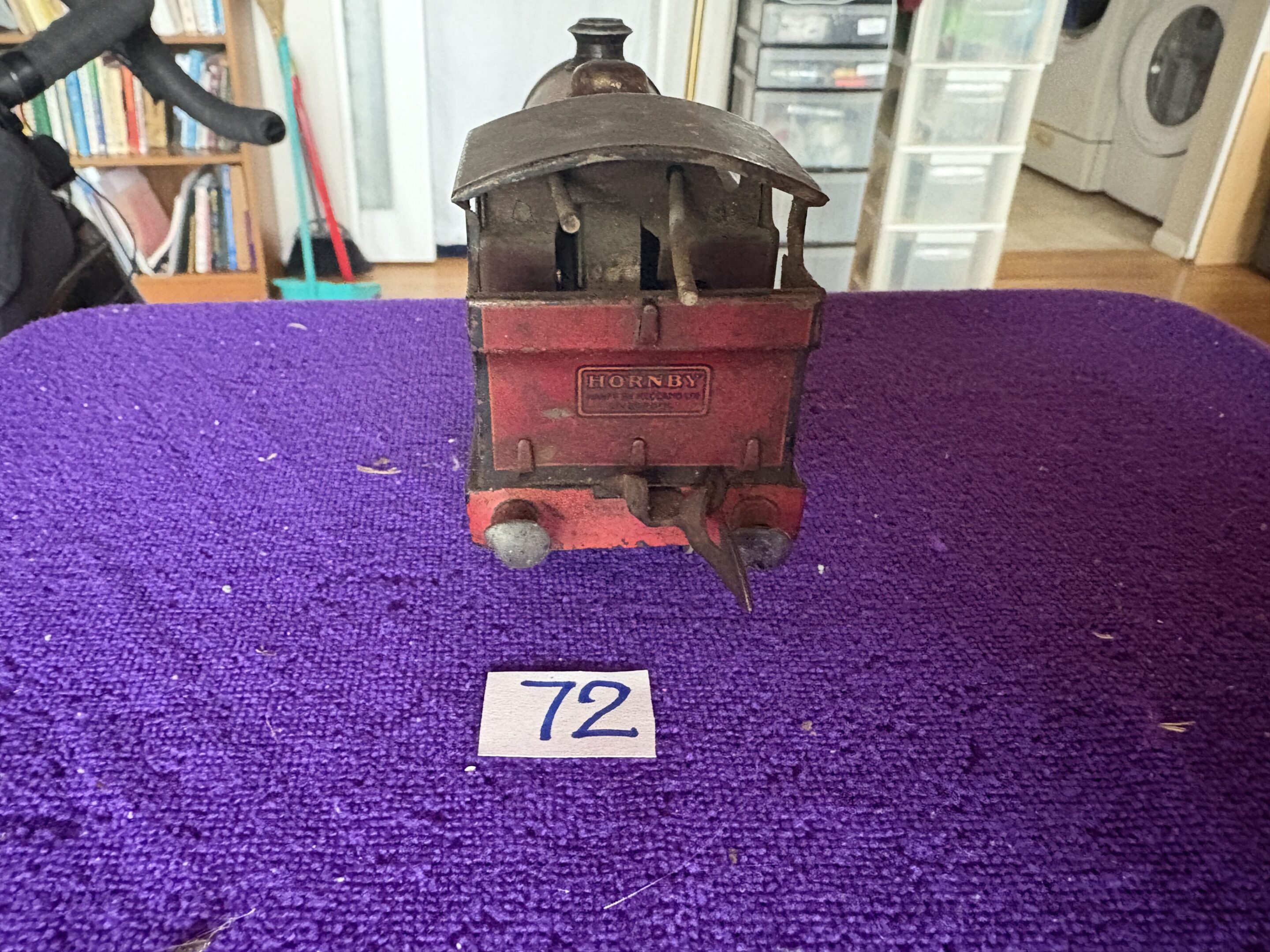 Vintage toy train car on a purple surface with a number 72 tag.
