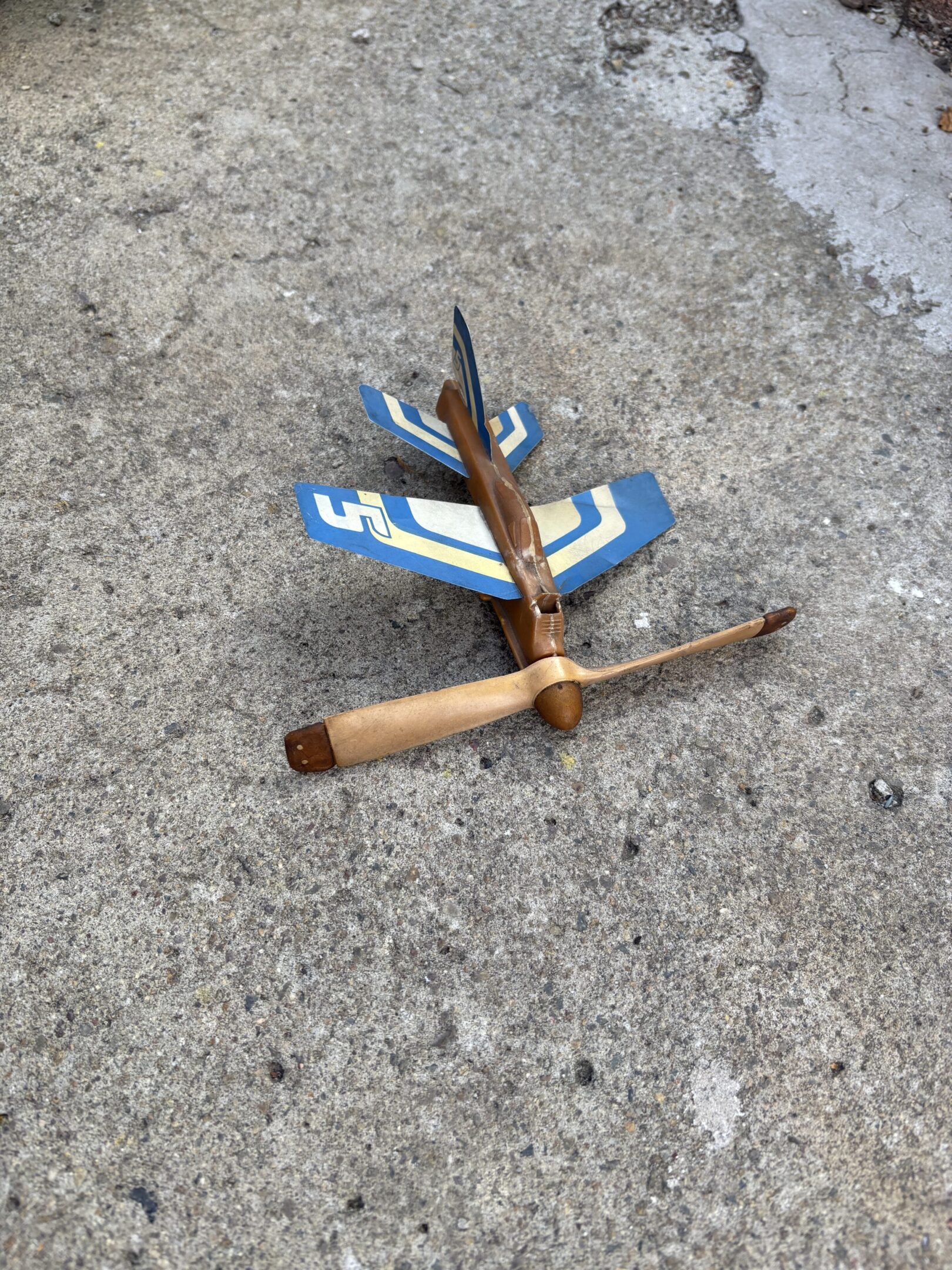 Rusty, bent street signs lying on concrete ground.