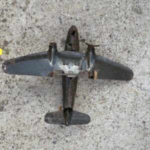 A vintage toy airplane on a concrete surface.