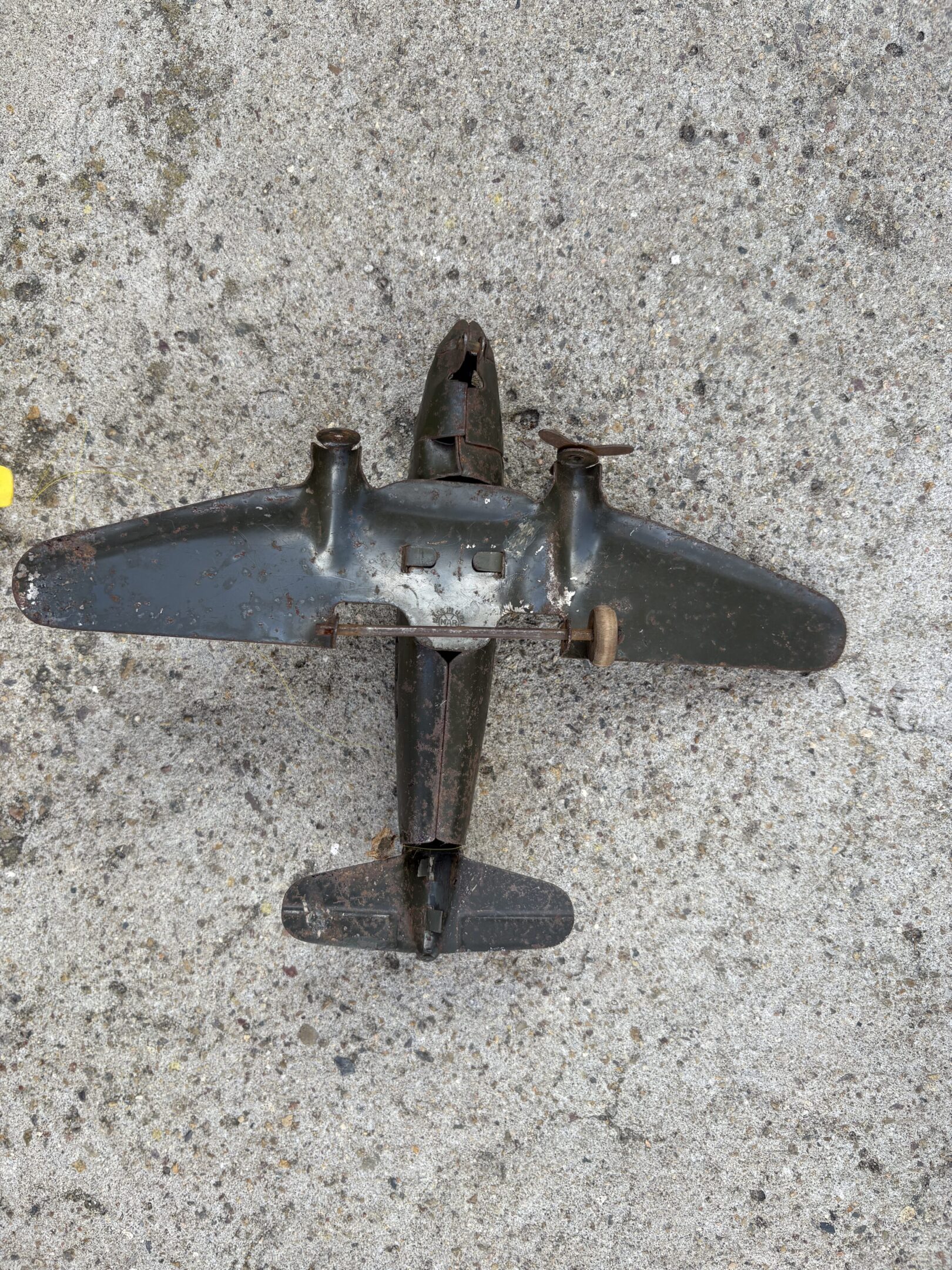 A vintage toy airplane on a concrete surface.