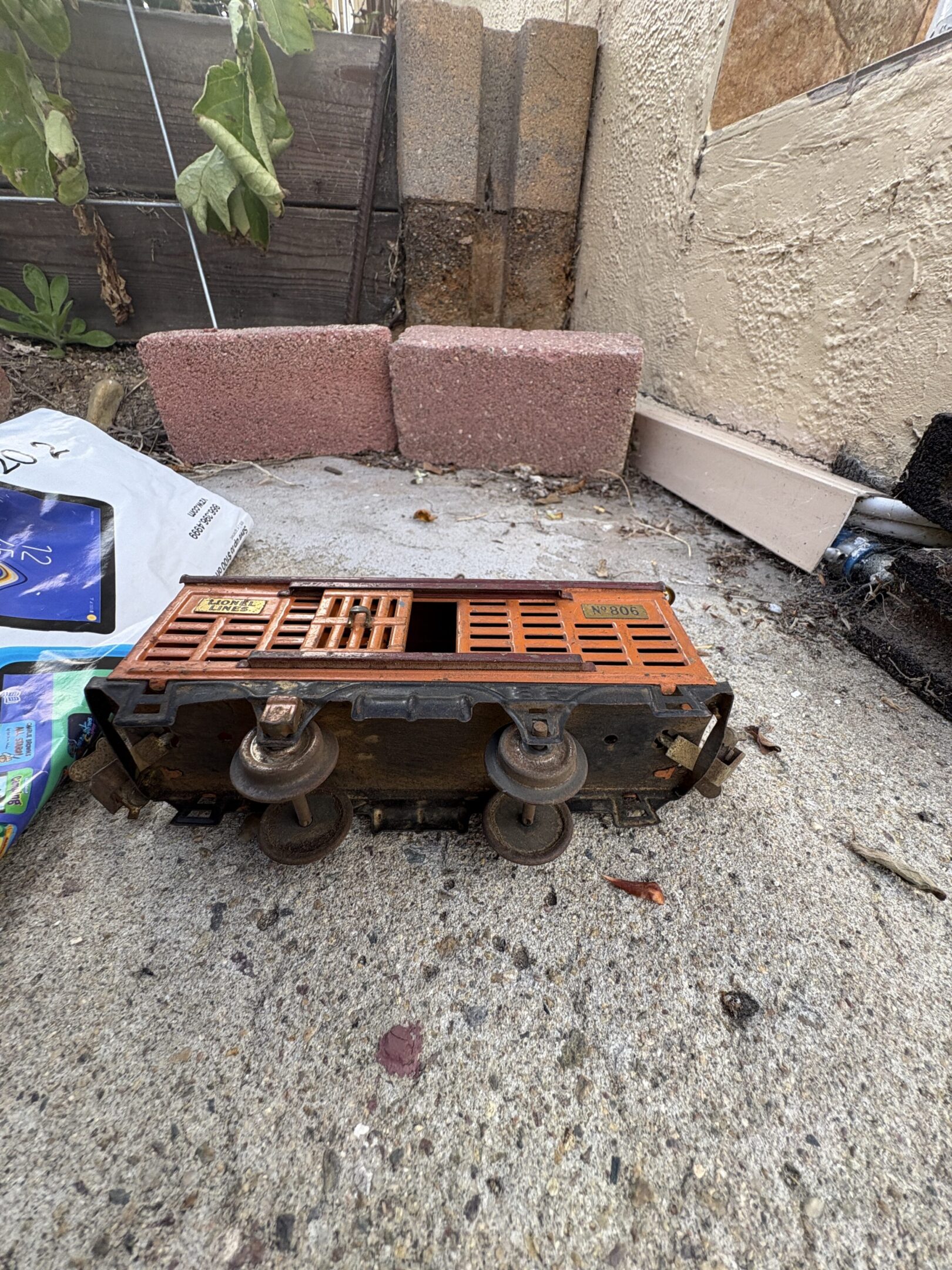 Old diesel engine fuel injector pump placed on the ground outdoors.