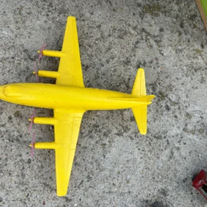 Yellow toy airplane on a gray surface.