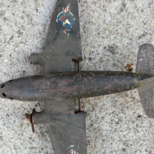 Rusty, old model airplane lying on a rough surface.