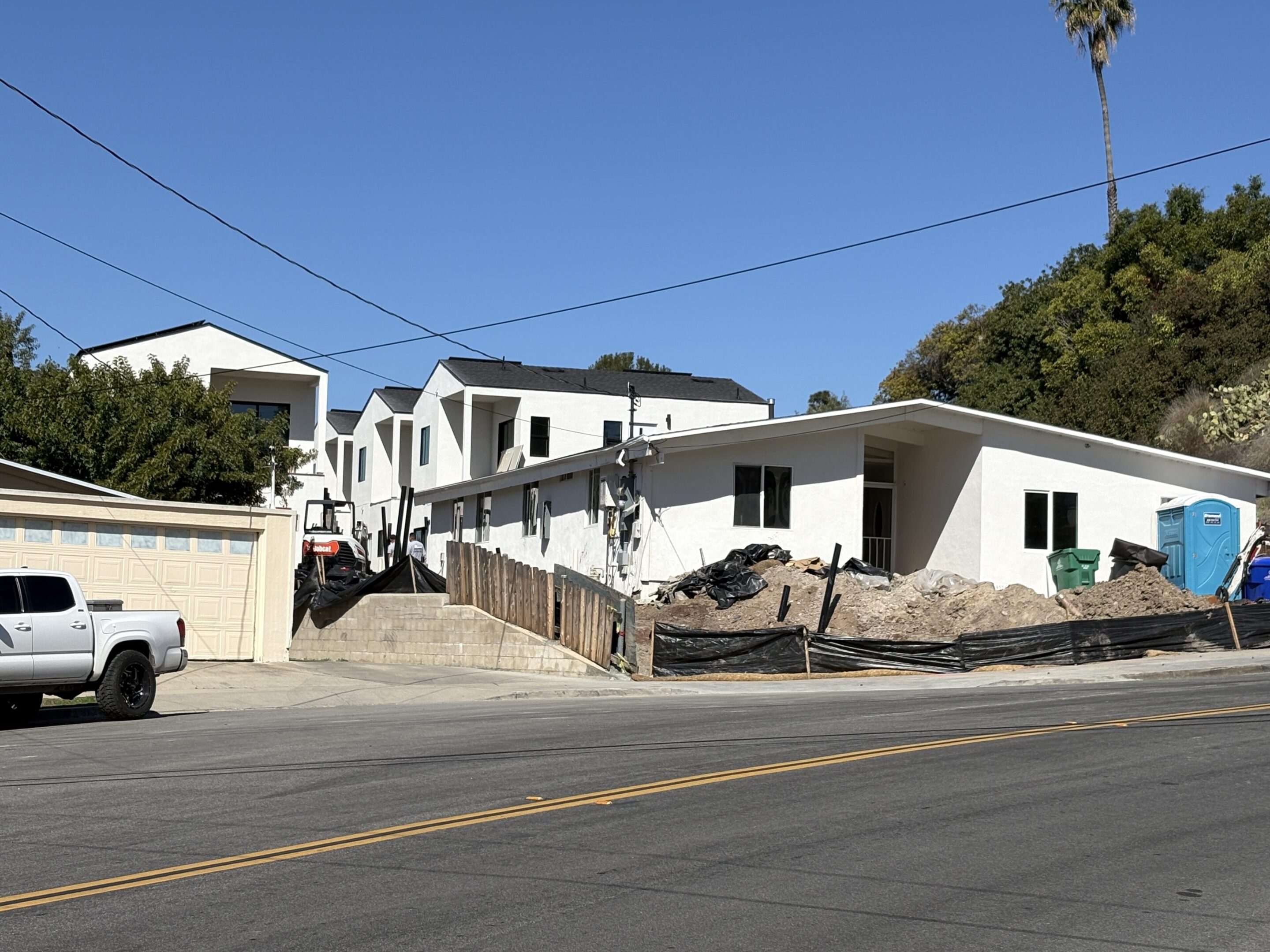 White houses on a sunny street with clear blue sky.