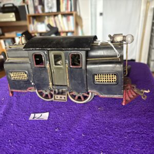 Vintage model train caboose on a purple cloth.