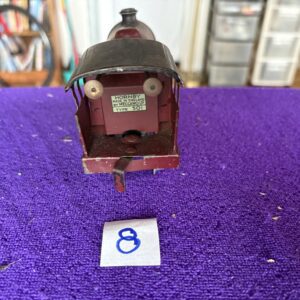 Close-up of a vintage train model's rear with a purple background.