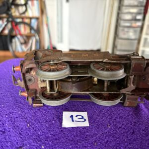 Close-up of a vintage toy train car on a purple surface with number 13 card.