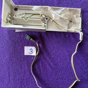 Disassembled vintage electric hair clipper with cord on purple fabric.