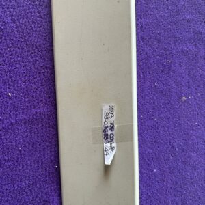 A small, white, rectangular object with barcodes on a textured surface.