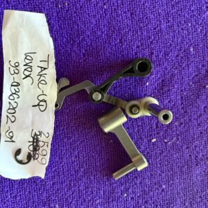 Two small metal mechanical parts on a purple surface with a handwritten note.