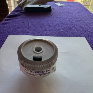 A round metallic object with text wrapped around it on a white paper.