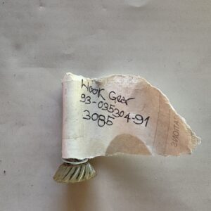 A small note with handwritten text and a shell beside it.