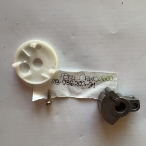 Two small, plastic mechanical parts on a white surface with a label.
