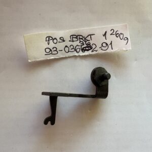 Small black metal mechanical part with handwritten label.