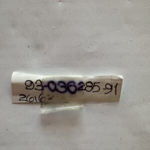 A small white cylindrical object with handwritten numbers and letters.