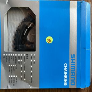 Shimano bike chainring in blue packaging with visible teeth.