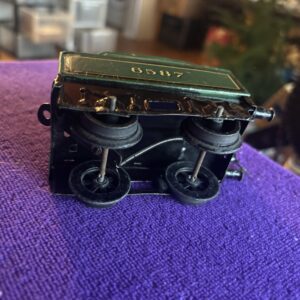 Vintage black binoculars resting on a purple fabric surface.