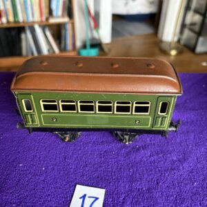 A vintage green and brown toy train car on a purple surface.