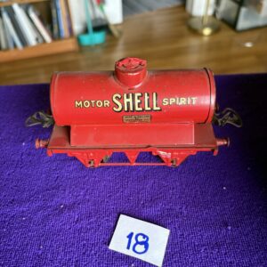 Vintage red Shell motor oil tanker toy on purple surface.