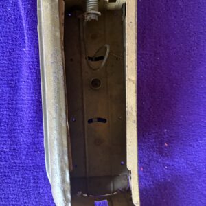 Close-up of an empty, metallic mechanical component with holes and slots.