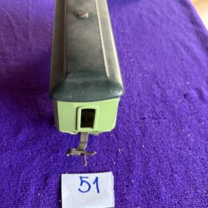 Close-up of a metal object with a slot, labeled number 51 on purple fabric.