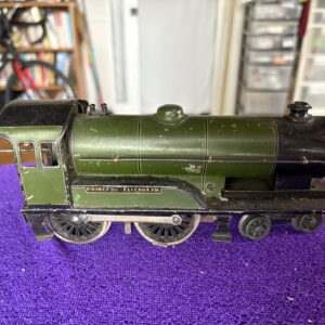 A green model steam locomotive on a purple surface.