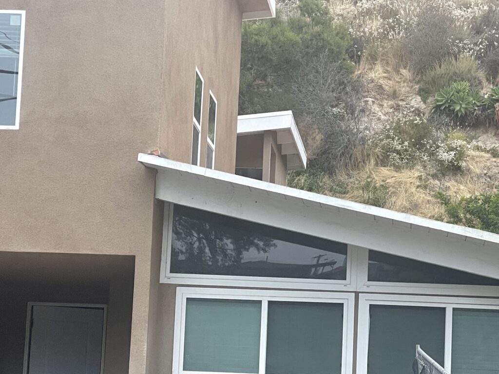 A modern house extension with large windows and a sloped roof.