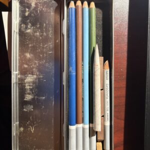 A collection of colored pencils arranged by size on a surface.