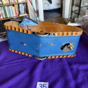 Vintage blue wooden violin case with a violin inside, resting on a purple cloth.