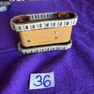 Vintage ceramic planter with piano key design on a purple cloth.