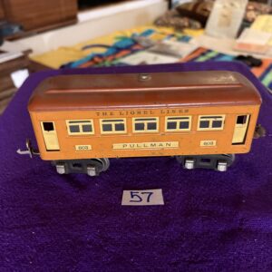 Vintage orange and yellow model train car on a purple surface.