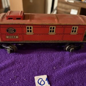 Vintage Lionel toy train car in red on purple fabric.