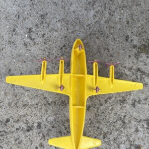 A yellow toy airplane on a gray surface.